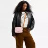 Mini sac bandoulière Carey en Signature Canvas avec Charms