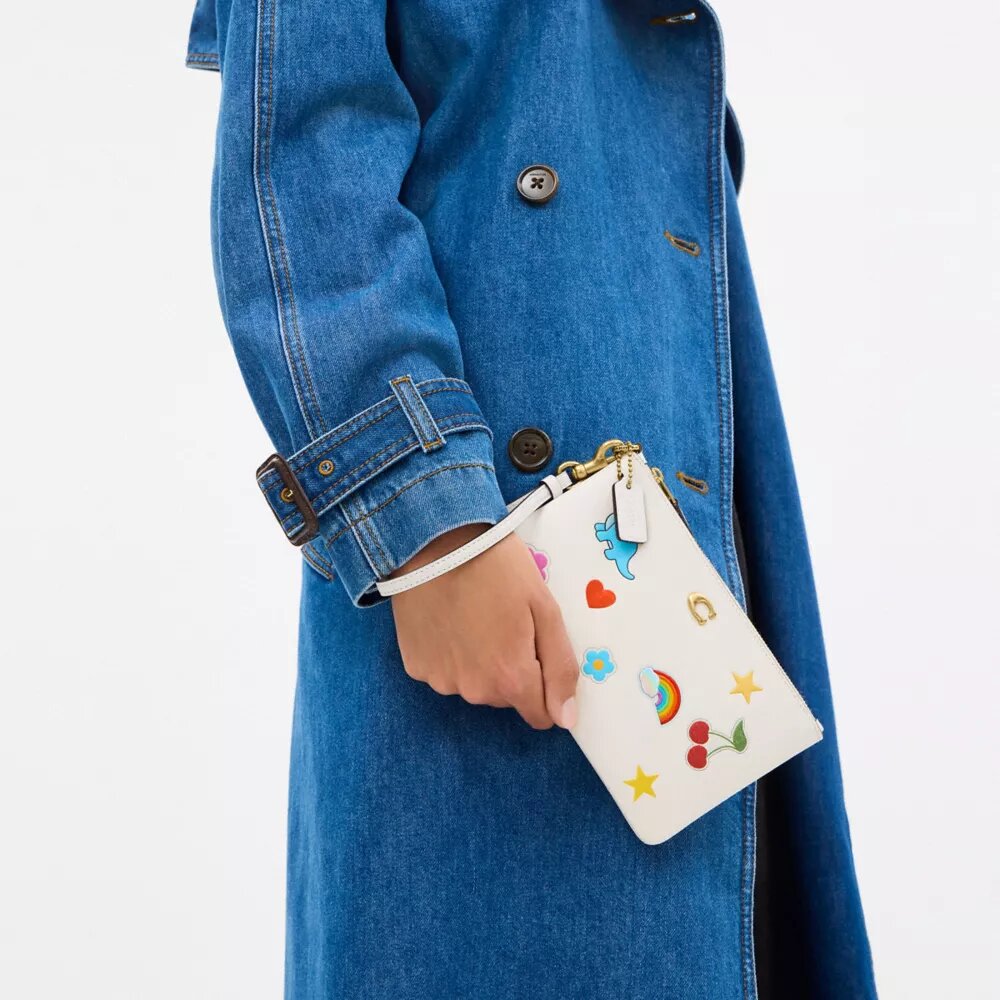 Petite pochette dragonne indispensable à imprimé autocollants