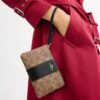 Pochette dragonne avec fermeture à glissière en coin en Signature Canvas à rayures