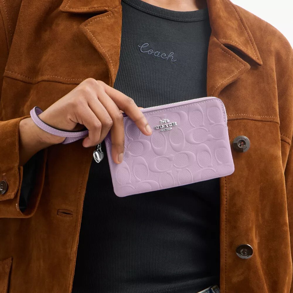 Pochette dragonne à fermeture éclair d'angle en cuir emblématique avec breloque en forme de cœur