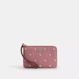 Pochette dragonne à fermeture éclair dans le coin avec rivets en forme de cœur