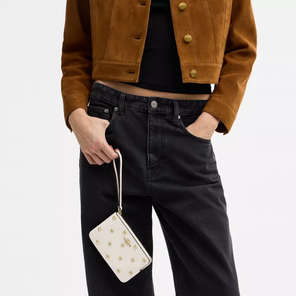 Pochette dragonne à fermeture éclair dans le coin avec rivets en forme de cœur