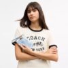 Pochette dragonne à fermeture éclair sur le côté en denim usé avec Charms