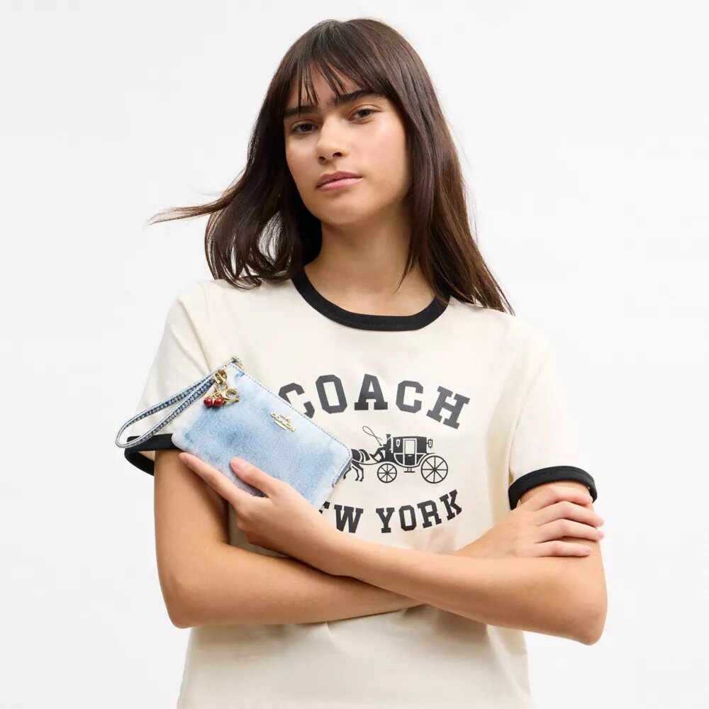 Pochette dragonne à fermeture éclair sur le côté en denim usé avec Charms